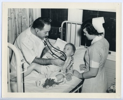 Student nurse and doctor with a young patient. 