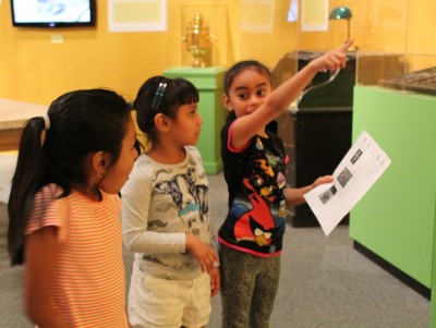 A girl from Hampstead Hill Camp points out an artifact to her friends.