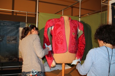 Collections Manager Joanna Church and Assistant Director Deborah Cardin install Mendes' newly conserved jacket.