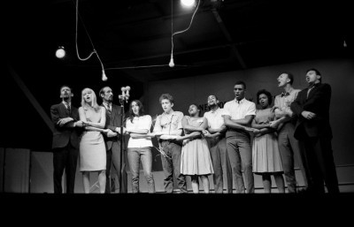 Peter, Paul and Mary, Joan Baez, Bob Dylan, the Freedom Singers, Pete Seeger, and Theodore Bikel photographed on July 26, 1963, by John Byrne Cooke at the Newport Folk Festival, singing “We Shall Overcome” with a standing audience of 13,000 joining in.