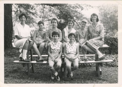 Girls and female counselors sitting on a picnic table. JMM 1993.37.22