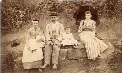 couple with their three children seated on rocks, most likely in a state park