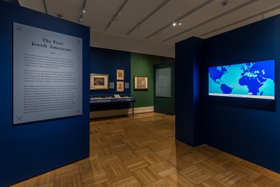 Photo of the entrance to an exhibit, with a text panel on the left and an illuminated world map on the right