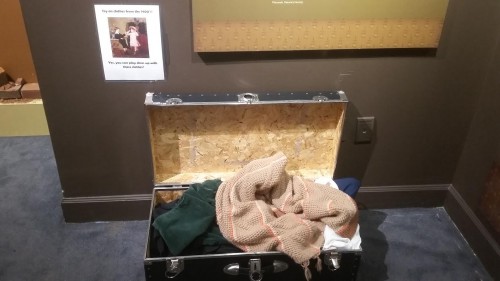 A suitcase full of clothes in the Voices of Lombard Street exhibit that allows children to become the people they learn about in the exhibit through literally putting on different clothing.