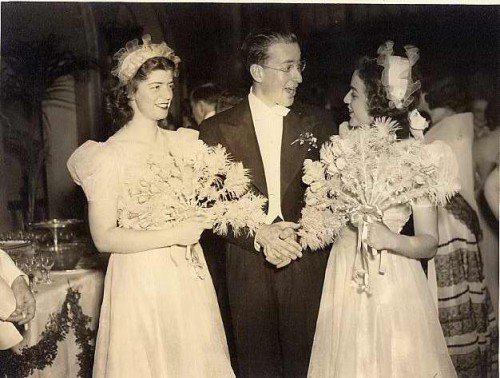 Left to right: Betty Hahn, Richard Lansburgh, and Selma Freedman at the wedding of Sidney Lansburgh, Jr. and Helen Brylawski at the Mayflower Hotel in Washington, D.C., 1940. In your imagination, please color their dresses aquamarine, their fans pink, and their hats beige with aqua ribbons. Gift of Margaret Nomentana. JMM 2004.108.9