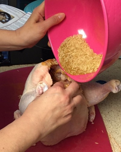Stuffing the chicken with rice.