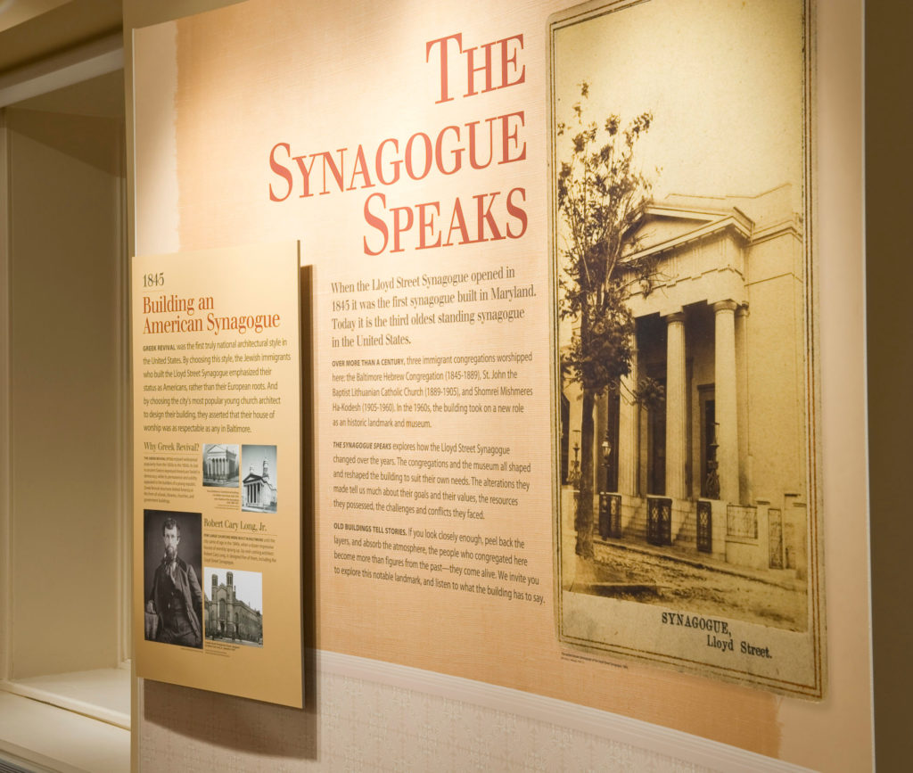 A panel in The Synagogue Speaks exhibit. The panel has text and images on it, including an early image of the Lloyd Street Synagogue. This exhibit is in the basement of the synagogue.