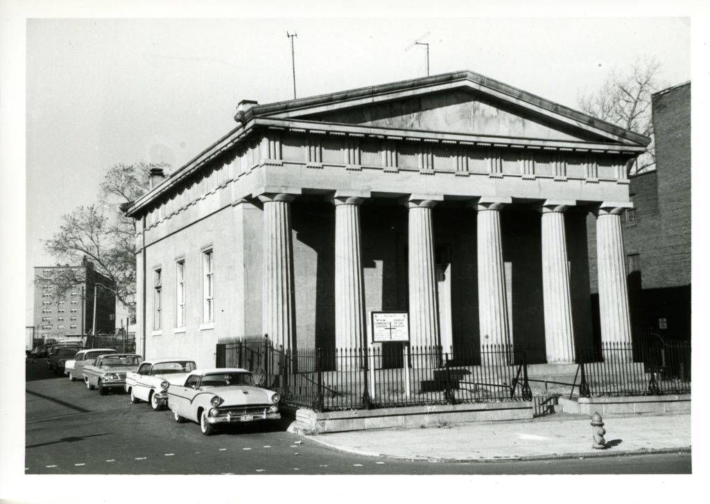 A black and white photo of the McKim Center, a Greek-style building with columns on the front.