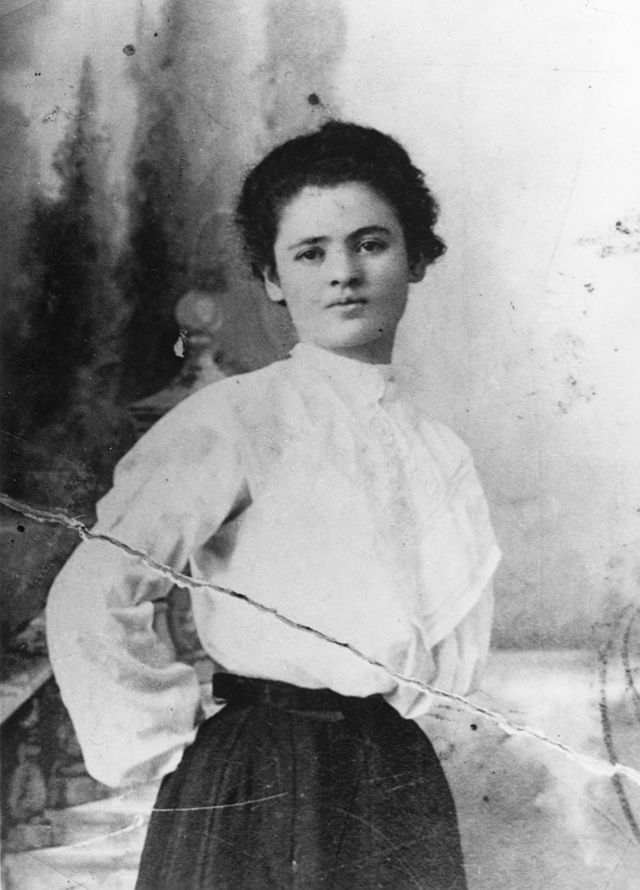  black and white early 20th century photograph of a young white Jewish woman wearing a white blouse and dark skirt.