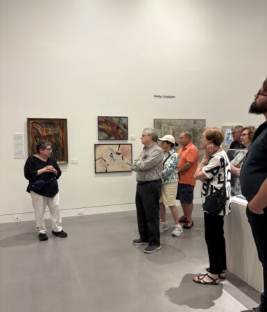 A group of individuals stand in an art exhibit
