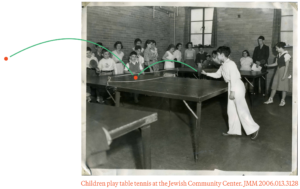 Black and white photograph of children playing table tennis.